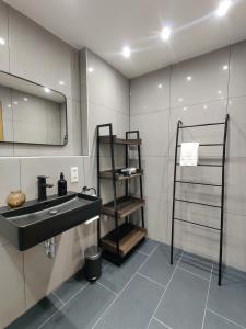 La salle de bains est pourvue d'un lavabo et d'un miroir. dans l'établissement 85qm, 4 bedroom, parking, King-Bed, Wifi, Netflix, à Waiblingen