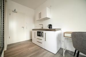 een kleine keuken met een koelkast en een tafel bij Livingboxx Karlsruhe in Rheinstetten
