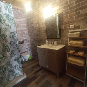 a bathroom with a sink and a brick wall at Casa do casal POIOS in Pombal