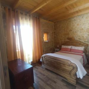 a bedroom with a large bed and a window at Casa do casal POIOS in Pombal