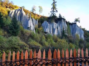 a fence in front of a mountain with rocks at Wiesenheimhof - Apt 1 in Terento