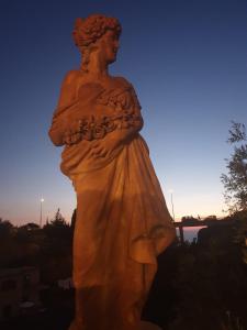 una estatua de una mujer parada en una colina en Antico Casale Sant'Anna 1905, en Massa Lubrense