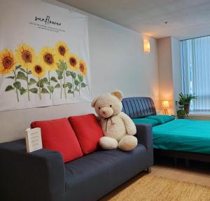 um urso de peluche sentado num sofá num quarto em Warm Studio em Incheon