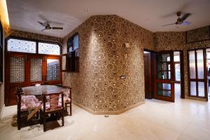 a dining room with a table and a wall covered in wallpaper at Madaan Villas in New Delhi