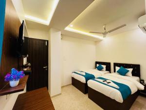 a hotel room with two beds with blue pillows at WELCOME VISTA in Navi Mumbai