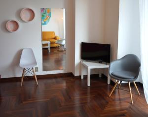 sala de estar con TV, mesa y sillas en COCO' HOUSE: PRESTIGIOSO APPARTAMENTO IN CENTRO en Turín