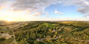 an aerial view of a forest with the sun setting at Agriturismo Villa Alari in Cetona