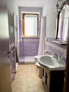 a purple bathroom with a sink and a toilet at Cumana Blu Apartments in Campofilone