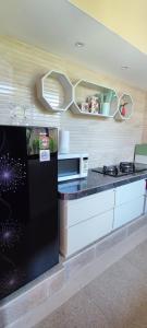 uma cozinha com um frigorífico preto e um micro-ondas em Accessible Penyaringan em Sanur