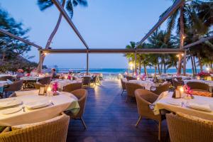 - un restaurant sur la plage avec des tables et des chaises dans l'établissement Anantasila Beach Resort Hua Hin, à Hua Hin