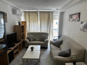 uma sala de estar com um sofá e uma televisão em Sevilla Apartamento en Camas a minutos del centro de Sevilla Wifi em Camas