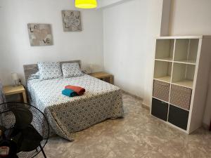 um quarto com uma cama e uma estante de livros em Sevilla Apartamento en Camas a minutos del centro de Sevilla Wifi em Camas