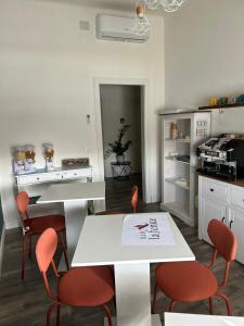 una cucina con sedie arancioni e tavolo bianco di B&B La Fenice a Bologna