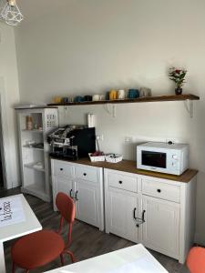 a kitchen with white cabinets and a microwave on a counter at B&B La Fenice in Bologna
