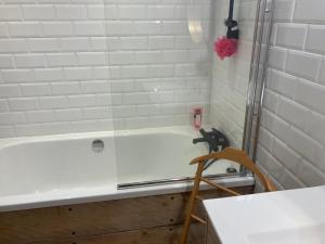 een badkamer met een bad en een wastafel bij Coup de coeur avec terrasse à 3 minutes des Arènes in Nîmes