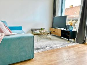 sala de estar con sofá azul y TV en Central Apartment Budapest ~ Roof Terrace/AC/Indoor parking, en Budapest