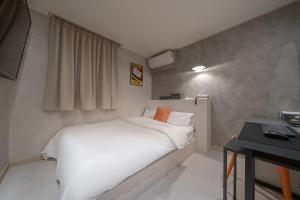 - une chambre avec un lit blanc et un bureau dans l'établissement Uiwang Nine Hotel, à Uiwang