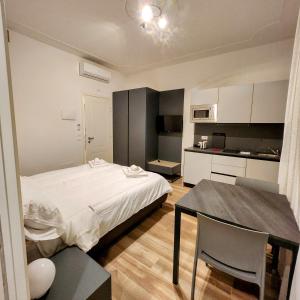Cet appartement comprend une chambre avec un lit et une table ainsi qu'une cuisine. dans l'établissement b&b marconi 49, à Bologne