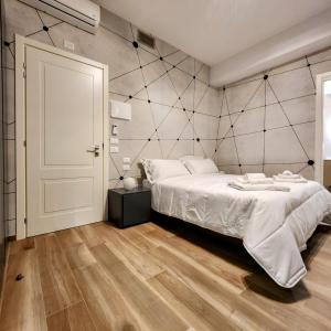 Schlafzimmer mit einem großen weißen Bett und Holzböden in der Unterkunft b&b marconi 49 in Bologna