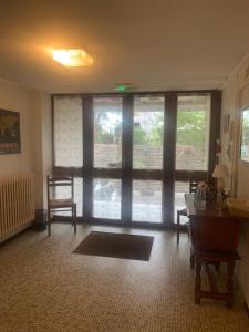 ein Wohnzimmer mit einem großen Fenster und einem Tisch in der Unterkunft Villa Cécilia in Lourdes