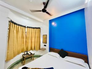 een blauwe muur in een slaapkamer met een bed bij Ganga Guest House in Varanasi