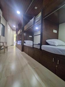 a row of beds in a room with mirrors at DC Dormitory Asalpha Metro in Mumbai