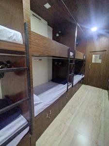 grupa łóżek piętrowych w pokoju w obiekcie DC Dormitory Asalpha Metro w Bombaju