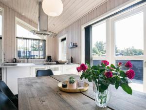 une cuisine avec une table en bois et des fleurs dans un vase dans l'établissement 10 person holiday home in L kken, à Løkken