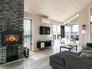 - un salon avec une cheminée et un canapé dans l'établissement 10 person holiday home in L kken, à Løkken