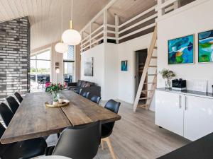 - une salle à manger et un salon avec une table et des chaises en bois dans l'établissement 10 person holiday home in L kken, à Løkken