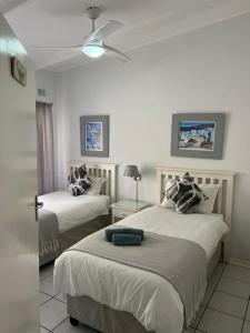 1 dormitorio con 2 camas y ventilador de techo en Villa Del Sol Unit 8, en Margate