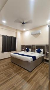 a bedroom with a large bed with blue pillows at HOTEL THE VILLA in Bhopal