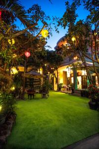 un patio de una casa con césped verde y luces en Ngan Phu Villa, en Hoi An