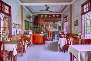 a restaurant with tables and chairs and stained glass windows at Ngan Phu Villa in Hoi An