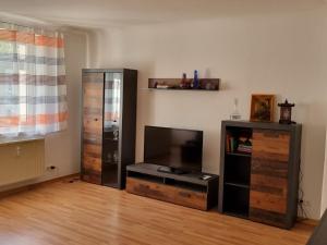 ein Wohnzimmer mit einem Flachbild-TV und einem Entertainment-Center in der Unterkunft Ferienwohnung Böttger in Dresden