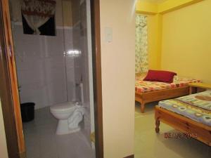 a bathroom with a toilet and a bathroom with two beds at TRIPLE JS INN-SAGADA in Sagada