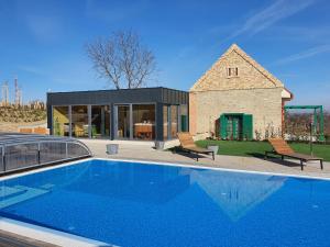 a house with a swimming pool in front of a house at Herczeg-Fekete Cottage Birtokközpont in Simontornya