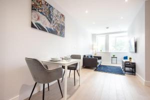un soggiorno bianco con tavolo e sedie di Space Apartments - Library House, Secure Parking, fast Wifi, Central Brentwood a Brentwood
