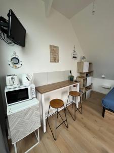 a small kitchen with a table and two stools at La Pose Normande in La Cerlangue