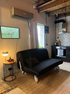 a living room with a black couch and a table at Lillahuset i Helsingborg! in Helsingborg