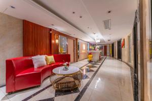 a living room with a red couch and a table at Windsleep International Apartment Hotel-Free delivery to the venue of the Canton Fair&Cantonese Breakfast in Guangzhou