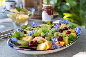 a plate of fruit and vegetables on a table at Seaforth Country House in uMhlali