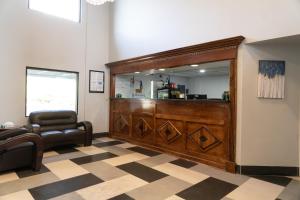 una sala de espera con espejo y silla en Royal Inn & Suites, en Akron