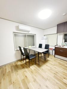 a dining room with a table and chairs in a kitchen at 無料駐車場有車種制限有!USjまで近く!空庭温泉徒歩圏海遊館!最大7名 in Osaka