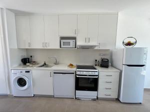 a kitchen with white cabinets and a washer and dryer at Papho's Mare Apts in Paphos +13 photos