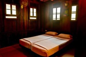 a bedroom with a bed in a room with windows at Omsam Guest Home in Varkala