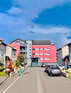 a parking lot with cars parked in front of a building at Le Cocon des Thermes Amneville Metz Luxembourg in Amnéville