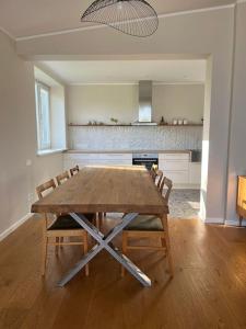 a kitchen with a wooden table and chairs in a room at Ģimenes māja Jaunpilī in Jaunpils