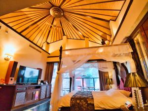 a bedroom with a canopy bed and a television at SKY PARADISE スカイパラダイス　ラクエン in Oita