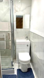 a white bathroom with a toilet and a shower at 7 Venus Road (Room 7) in London